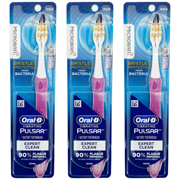 Three Oral-B Vibrating Pulsar Battery Toothbrushes, Expert Clean Medium Bristles in pink, are shown standing vertically side by side. Sold as a 3 Pack, they help remove up to 90% of plaque with powerful vibrating bristles.
